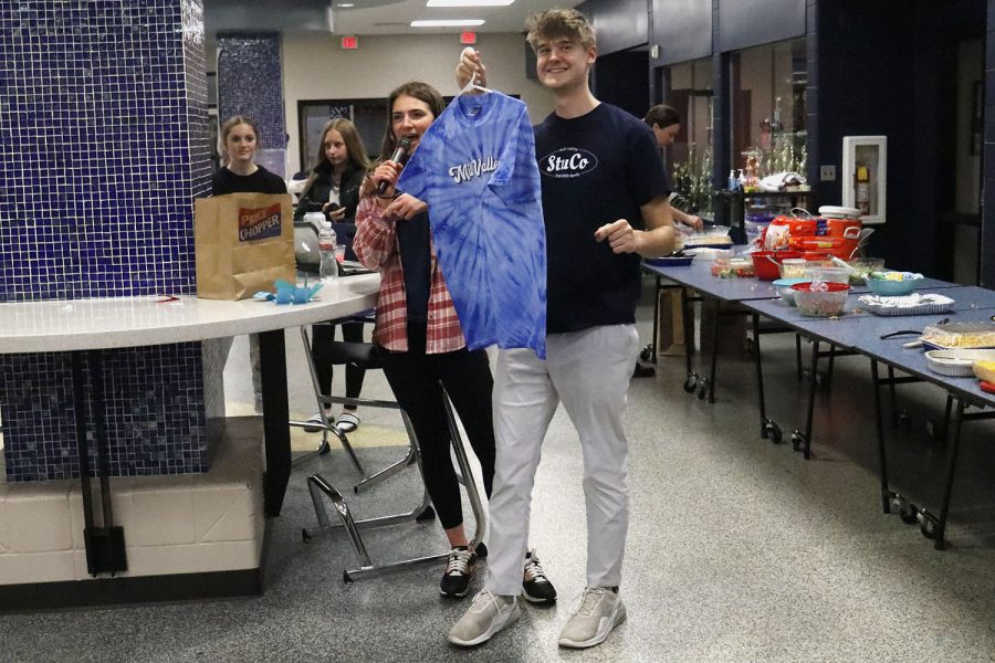 At the end of the night, senior Bret Weber holds a Catty Shack shirt as senior Logan Pfiester announces the winner of the raffle.