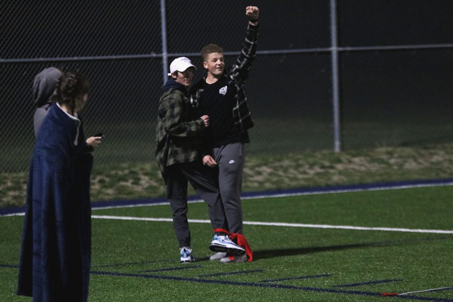 Turning toward the score board, senior Declan Taylor and junior Sonny Pentola cheer as they hear their time. 