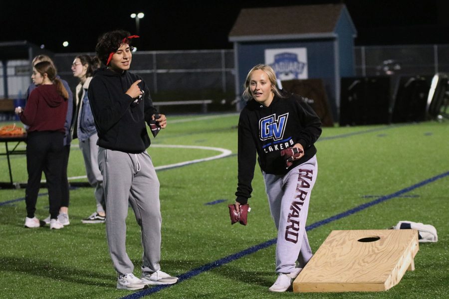 Leaning into the throw, junior Avery Blubaugh tries not to get distracted by senior Danny Talavera as she participates in the cornhole tournament Wednesday, Nov. 3. 