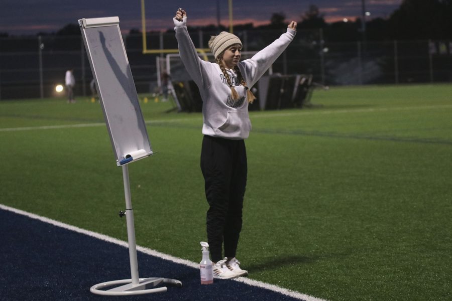 As she keeps score for the kickball game, senior Hadley Skinner dances to the music playing. 