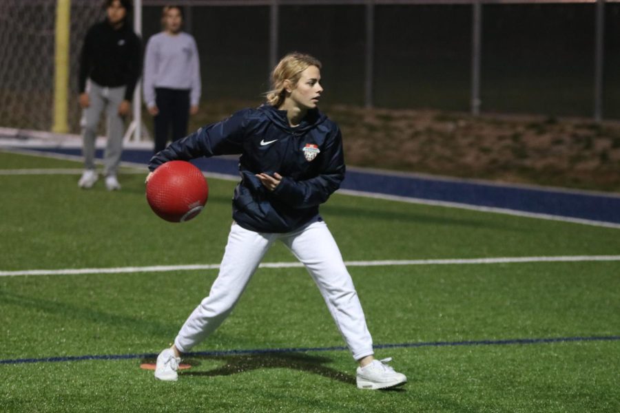 As she winds back her arm, junior Taylor Modrcin pitches the kickball.