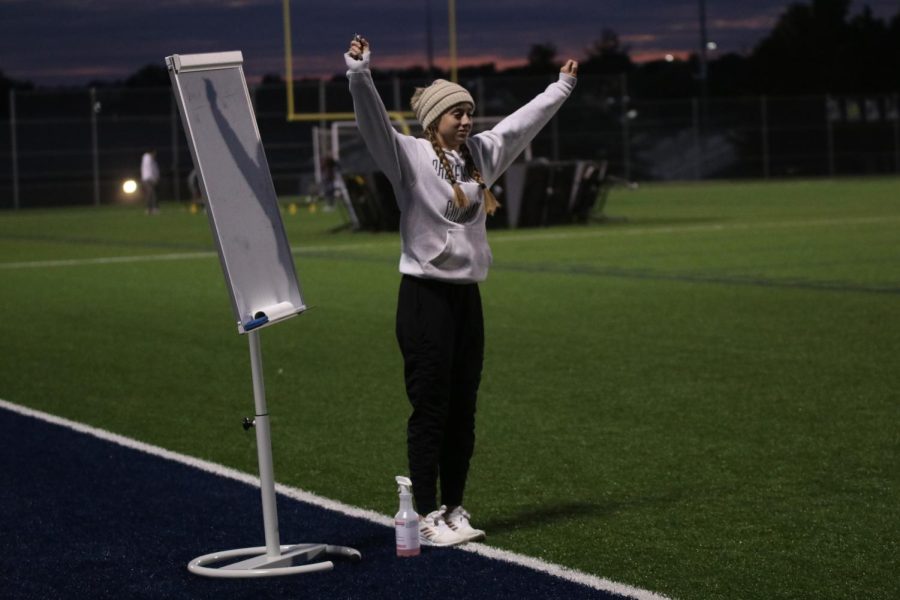 As she keeps score for the kickball game, senior Hadley Skinner dances to the music playing. 