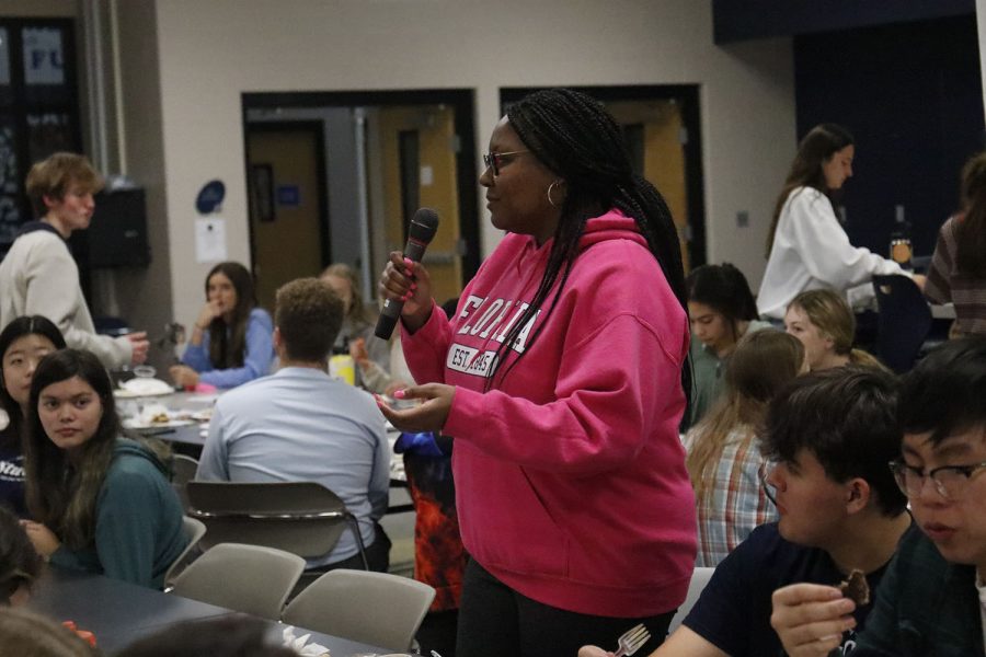 Holding the microphone, senior Hannah Hunter promotes the school choir. 