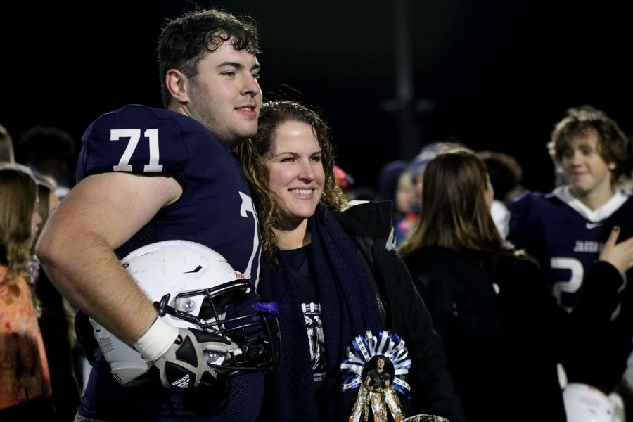 Looking at another camera, senior offensive lineman Ryan Fulcher poses with his mom for a picture after the game.
