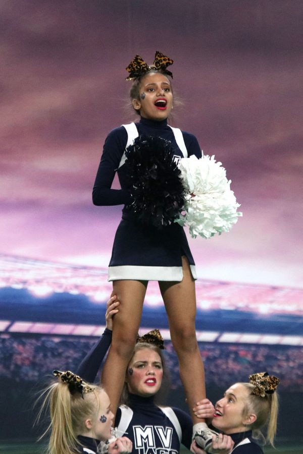 Cheering to the crowd, freshman Jada Winfrey gets stunted up in the air during her routine.