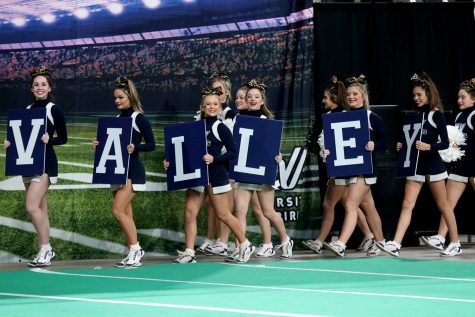 Walking out to the floor, individuals on the team carry signs with the letter that spell “VALLEY” at the state cheer competition Saturday, Nov. 20.