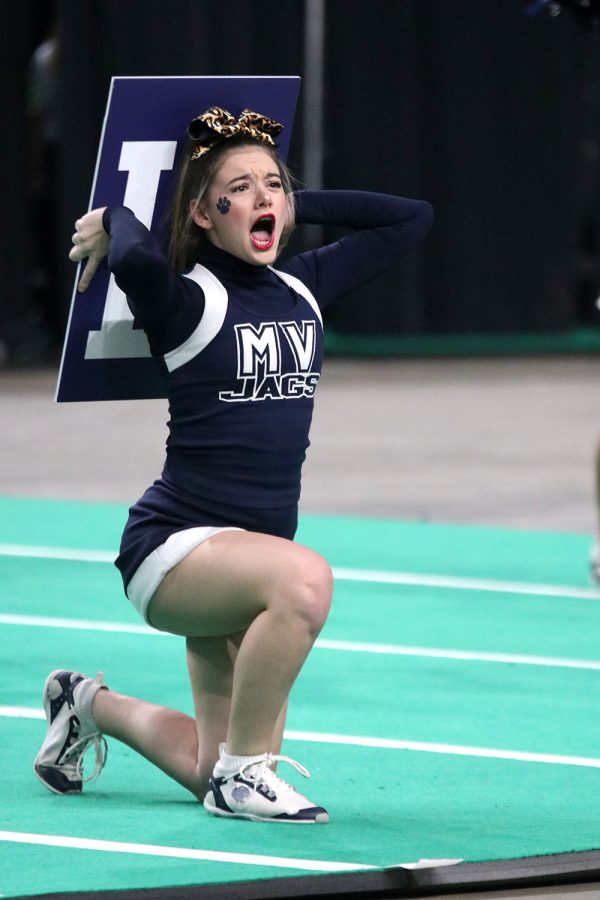 With her sign behind her back, sophomore Maci Burger yells her part of the chant to the crowd.