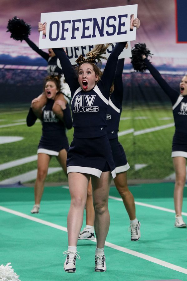 With the sign above her head, junior Kate Kline holds up the word “OFFENSE” towards the crowd.