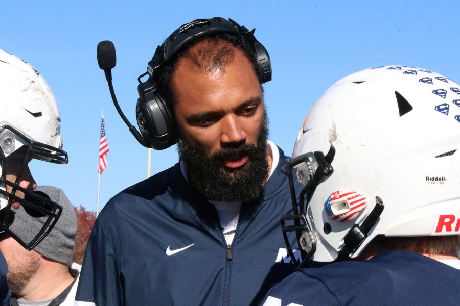 Before making their way onto the field, assistant coach Aaron Cox talks to the defensive line players. 