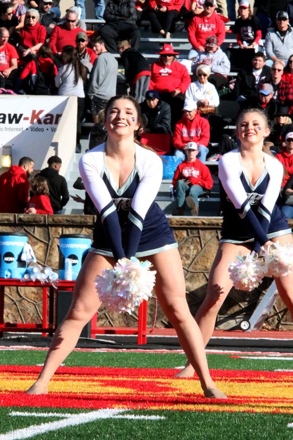 Pom poms together, senior Anna Brazil dances her routine to the beat of the music. 