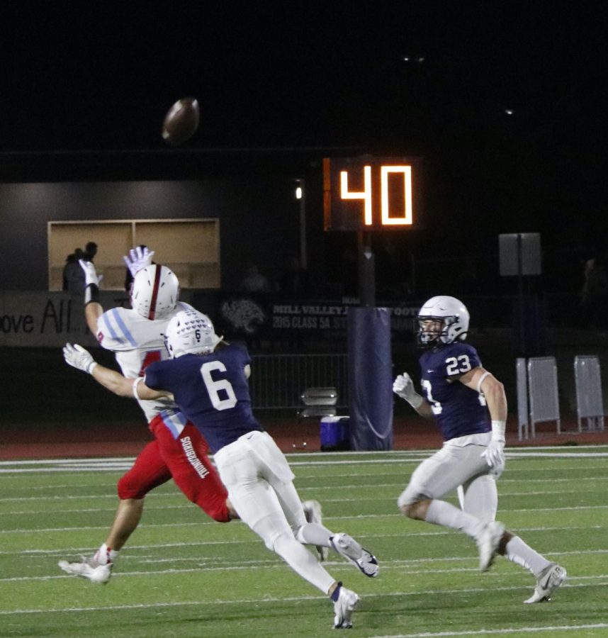 Leaping to the opponent, senior John Anderson tries to stop the receivers catch. 