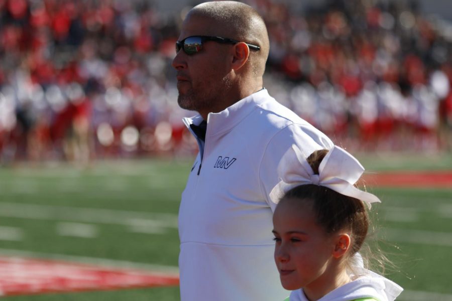 While waiting fo the national anthem to be played, coach Joel Applebee and daughter Lola Applebee look to the endzone at the flag.