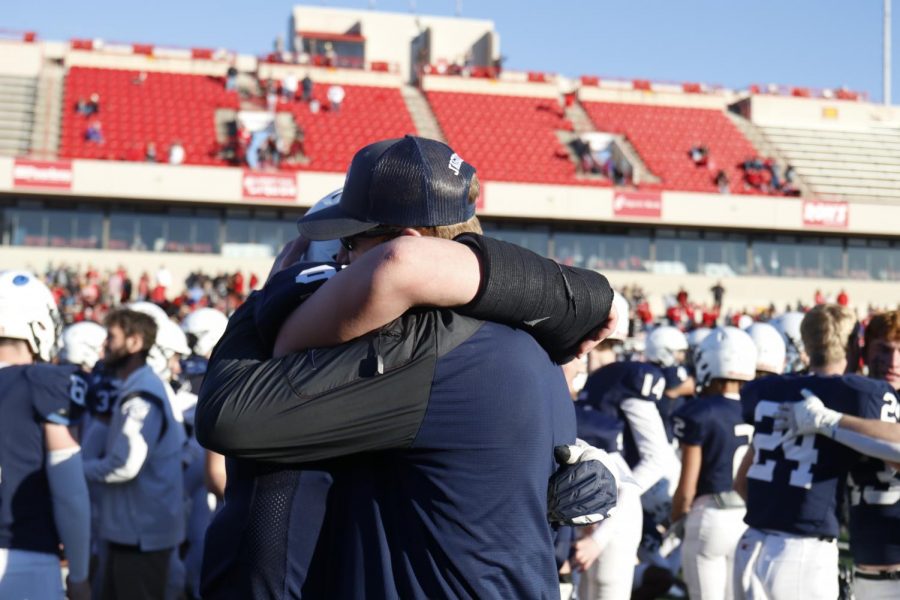 After winning his third state championship, senior Cody Moore hugs defense coach Andrew Hudgins.