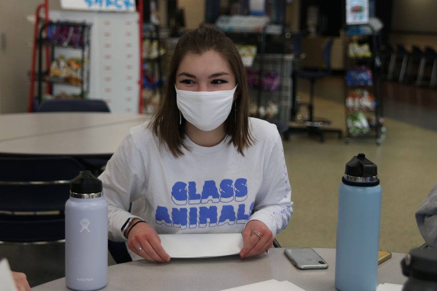 Laughing, senior Grace Emerson folds a card while talking with her peers Friday, Nov. 19. 