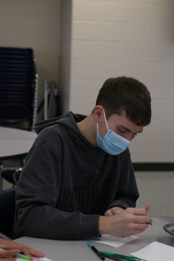 Preparing to write, senior Noah Webber thinks about what message he wants to write to a soldier Friday, Nov. 19. 