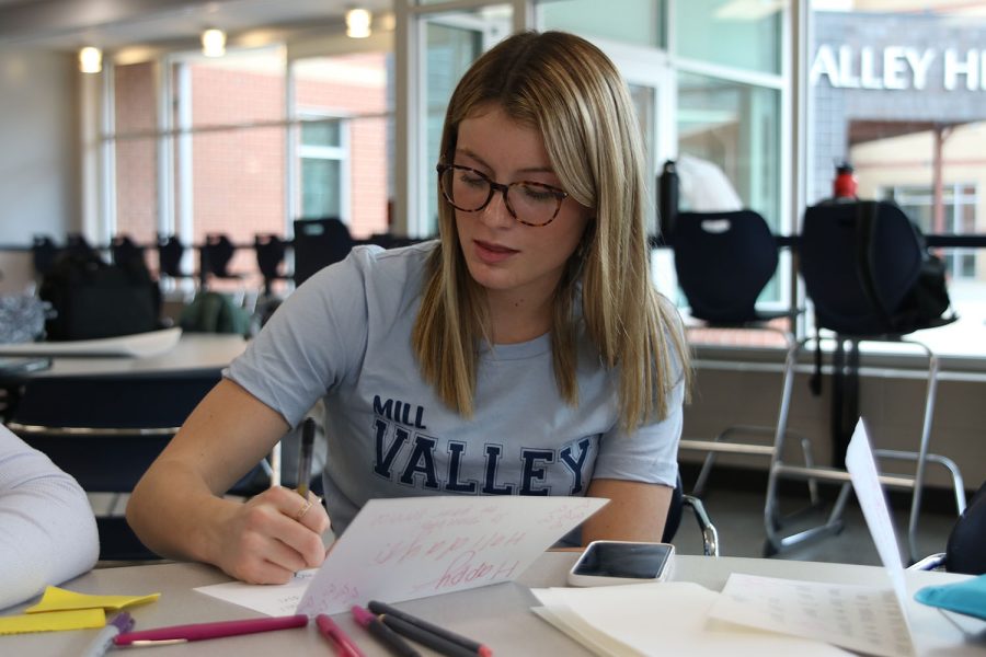 Drawing, junior Dylan Dedrickson illustrates an image on her card to send overseas Friday, Nov. 19. 