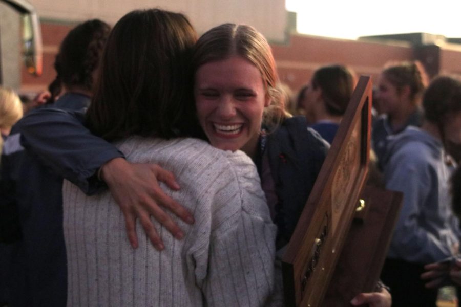 With a smile on her face, senior Katie Schwartzkopf hugs senior Maddy Williams. 