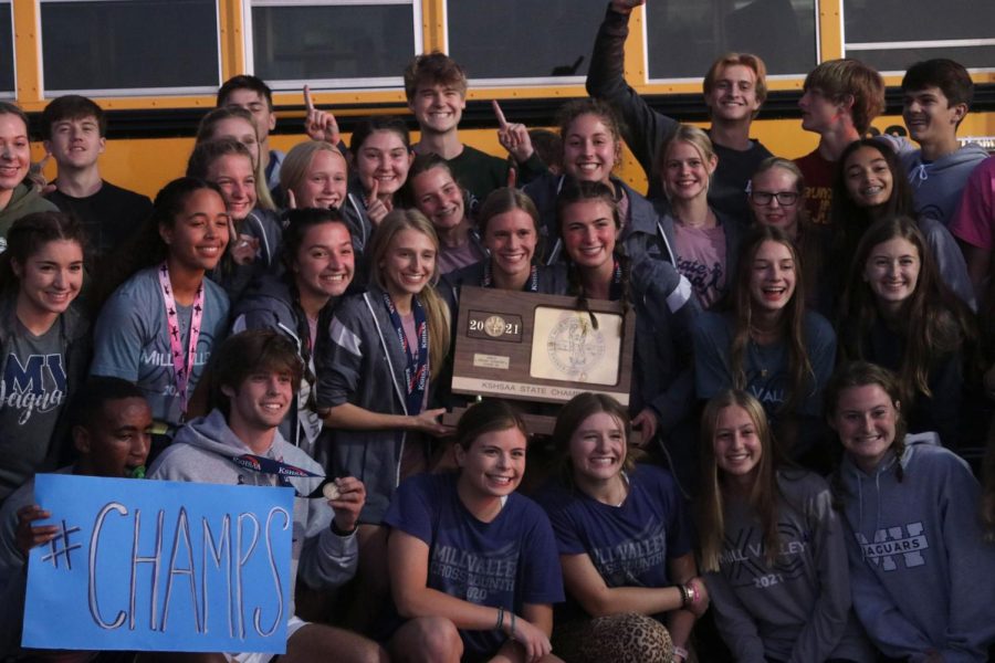 Surrounded by their teammates and supporters who came to welcome them, the team poses for a picture. 