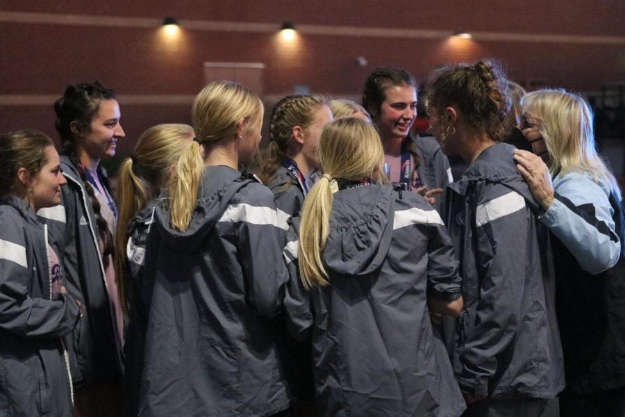 Huddled together, the team is congratulated by science teacher Betsy Meeks. 
