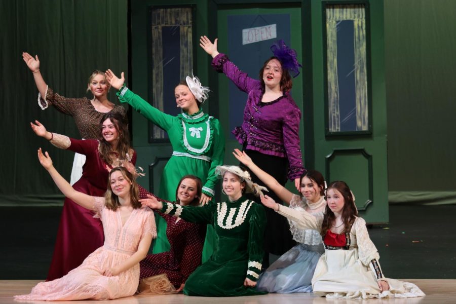 Cast members hold their arms out while singing one of the many songs. 
