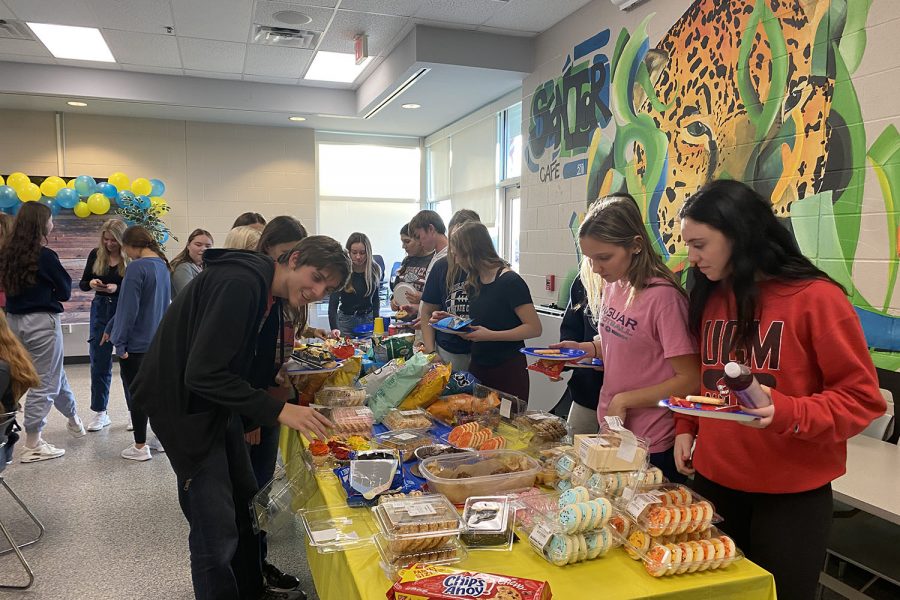 As they put food on their plate, juniors Garret Cowen, Camden Kaiser and Gracie Knight go through the buffet line.  
