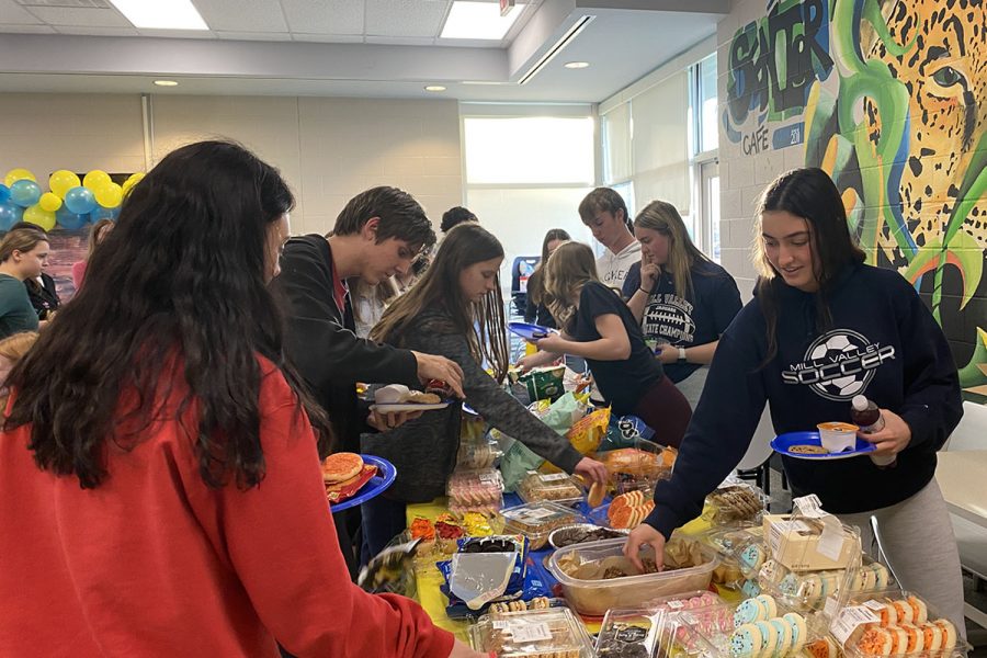                                                                                                                                                                                                                                                                                                                                                                                                                                                                                                                                                                                                                                                                                                                                                                       Grabbing food, junior Gracie Knight celebrates during the National English Honors Society initiation party. 