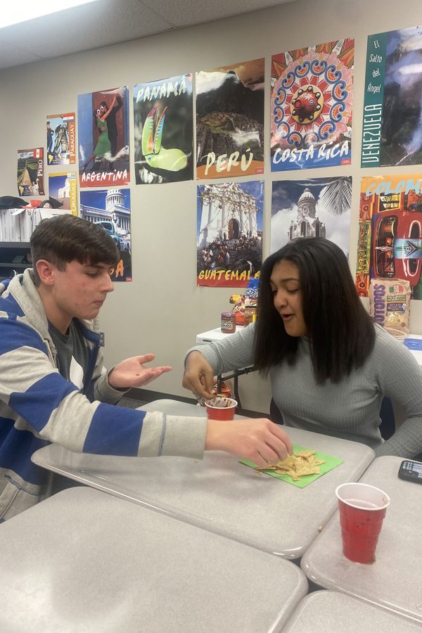 Participating in the Spanish Día de los Muertos (Day of the Dead) party, junior Bryce Jennings and sophomore Athena Solomon eat chips and salsa. 

