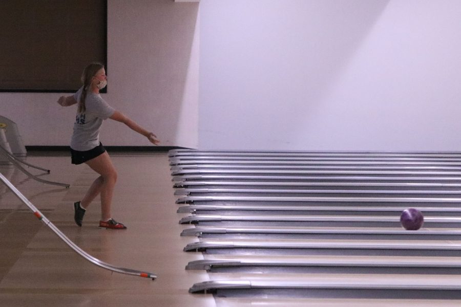 Watching the ball roll down the lane, junior Emma McCall waits to see how many pins she will hit.