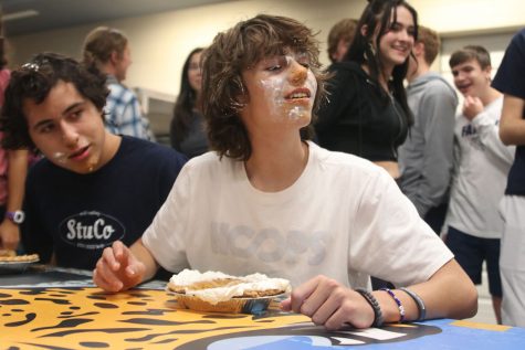 During the pie-eating contest, junior Eli Olson looks at his competitors’ pies to see how far along they are.
