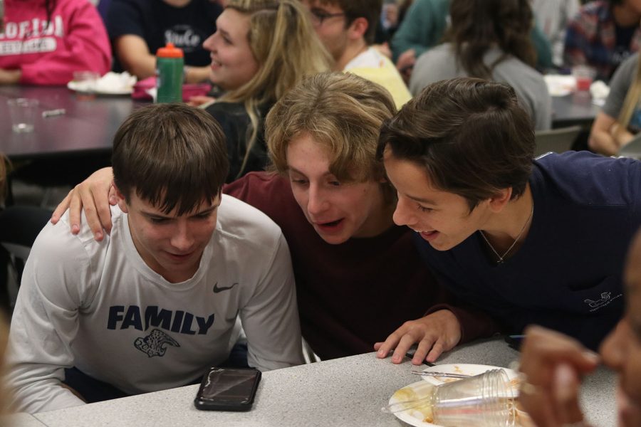 As the Kahoot results load, juniors Bryce Martin, Alex Shank and Carson McElroy crowd around to see if they win.