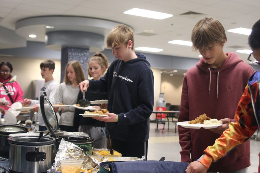 In the food line, freshman Logan Koester fills his plate.