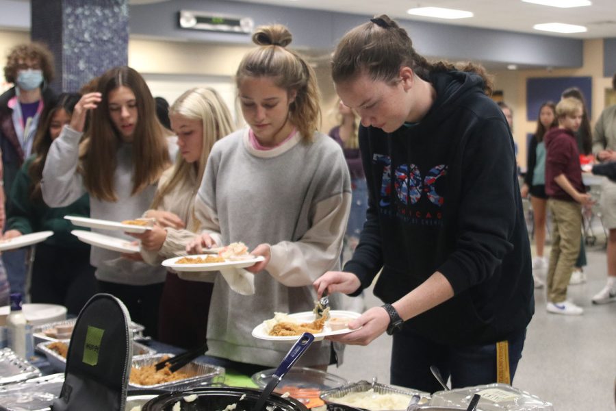 Holding their plates, seniors Mackinley Fields and Madison Vosburg get dinner.
