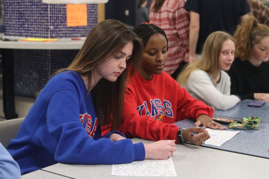 Before dinner, seniors Kennedy Yeoman and Aliya Kisivo color with crayons.
