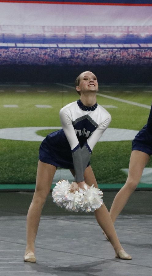 With her arms crossed, sophomore Alli Gervais smiles towards the crowd.