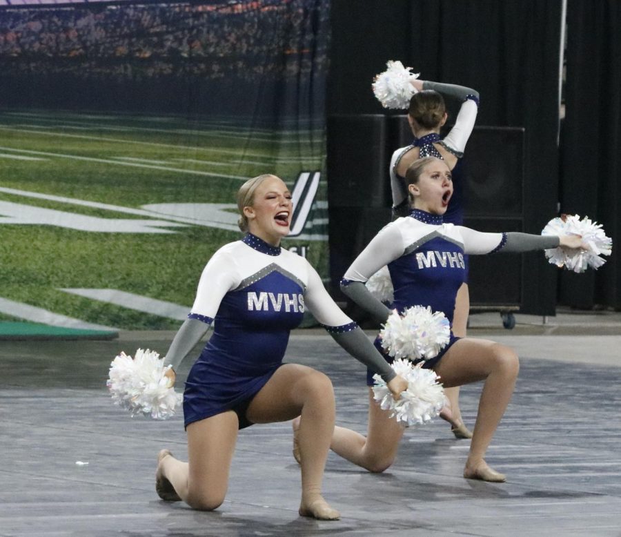 On one knee, senior Ella Lorfing and sophomore Trinity Baker pose during the routine.