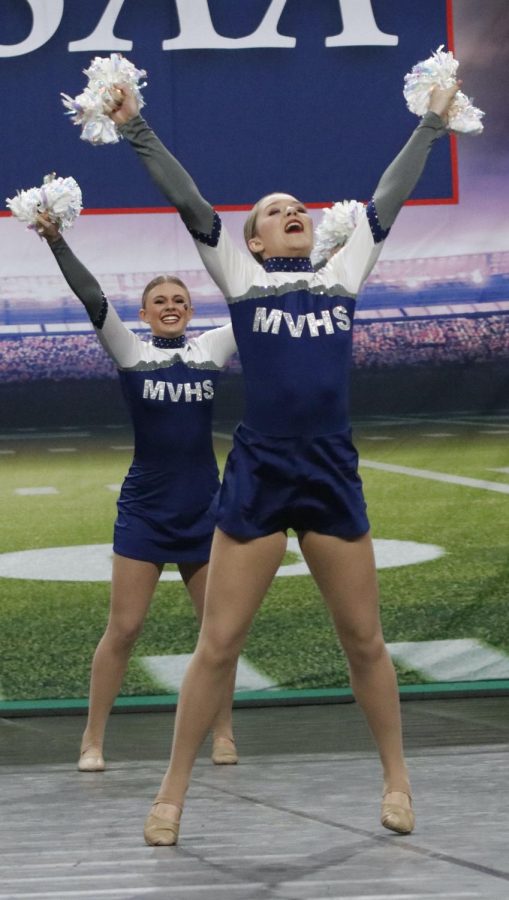 With hands in the air, sophomore Macy Bidnick looks up with a smile on her face.