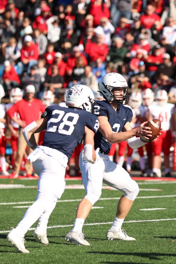 After the hike, junior quarterback Hayden Jay hands the ball to senior wide receiver Reice Kennedy. 