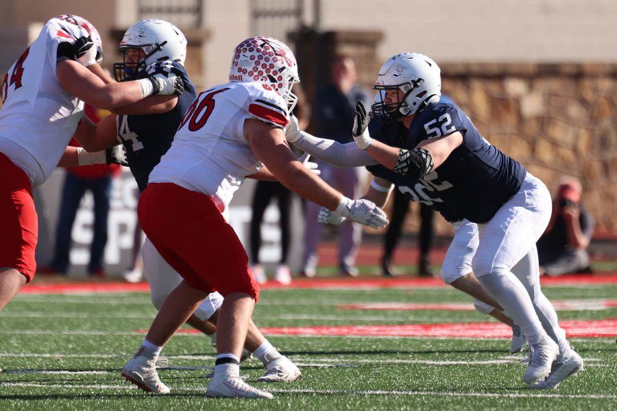 Pushing against the defensive player, junior defensive lineman Grant Rutkowski tries to break free to the quarterback. 