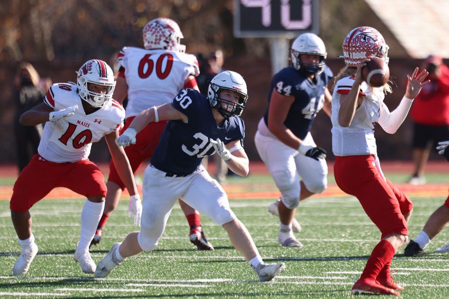 After breaking past the Maize player, junior linebacker Noah Coy runs to sack the quarterback. 