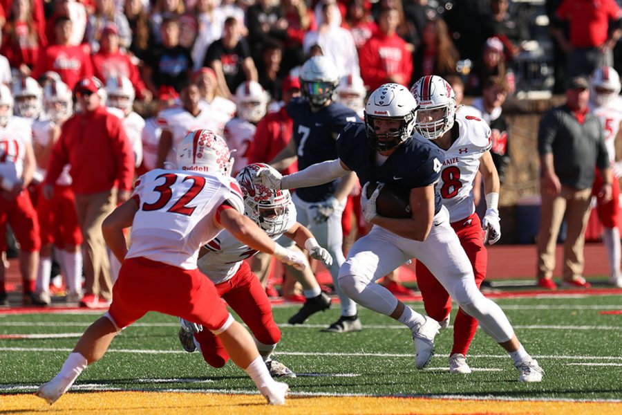 Pushing against the Maize players, senior wide receiver Sean Allerheiligen runs the ball down the field.