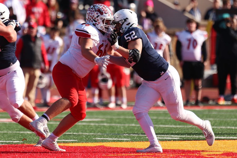 Budding his helmet against the opposing player, junior defensive lineman Grant Rutkowski tries to break past the line. 