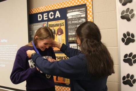 With a proud smile on her face, junior Libby Srathman receives a medal from senior Aneesa Ismail Wednesday, Nov. 3 for placing first in the Principals of Business Management category for DECA. My favorite part of the tournament was getting to hangout with my teammates in between rounds, Strathman said. The business club at BVHS gave all the comparators free drinks and snacks so it was a lot of fun.