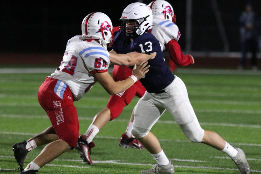 In an attempt to get through the offensive line, senior Payton Douglas battles with the opposing teams lineman. 