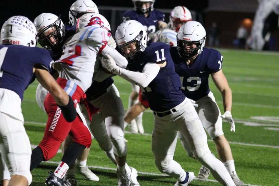 Battling the opposing teams ball carrier, senior Ben Fitterer tries to stop him from making it down field any further.