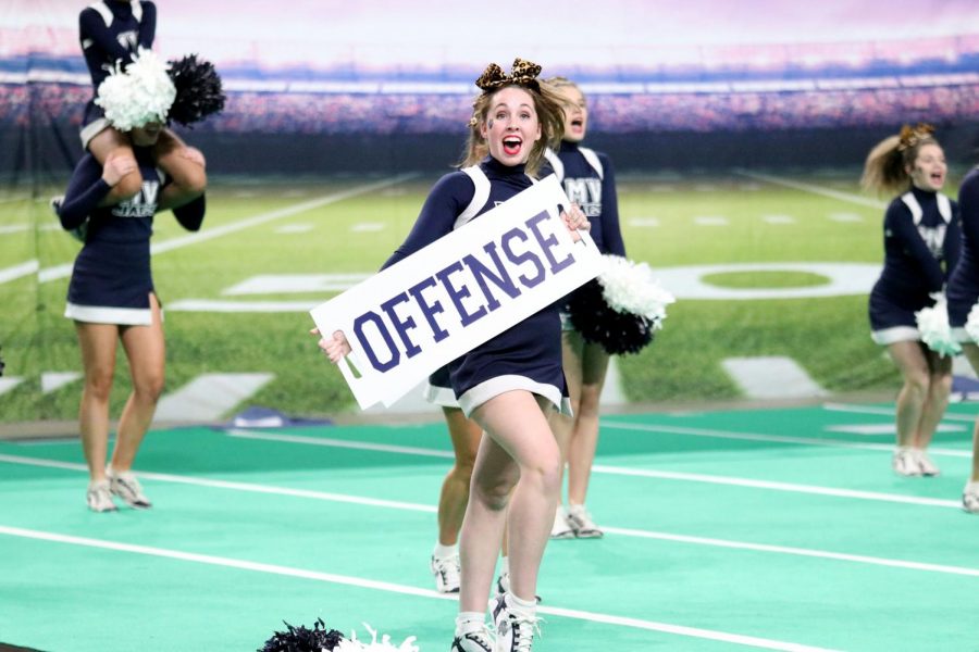 Performing the offensive cheer, junior Kate Kline holds her sign steady for the crowd to see. 