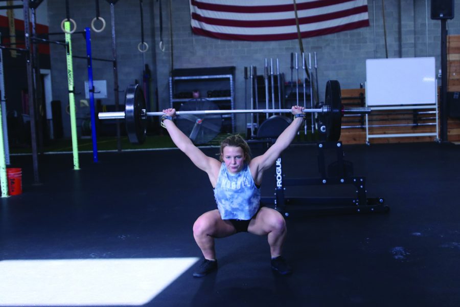 Sophomore Olivia Kersetter finishes a snatch by lifting the weight above her head