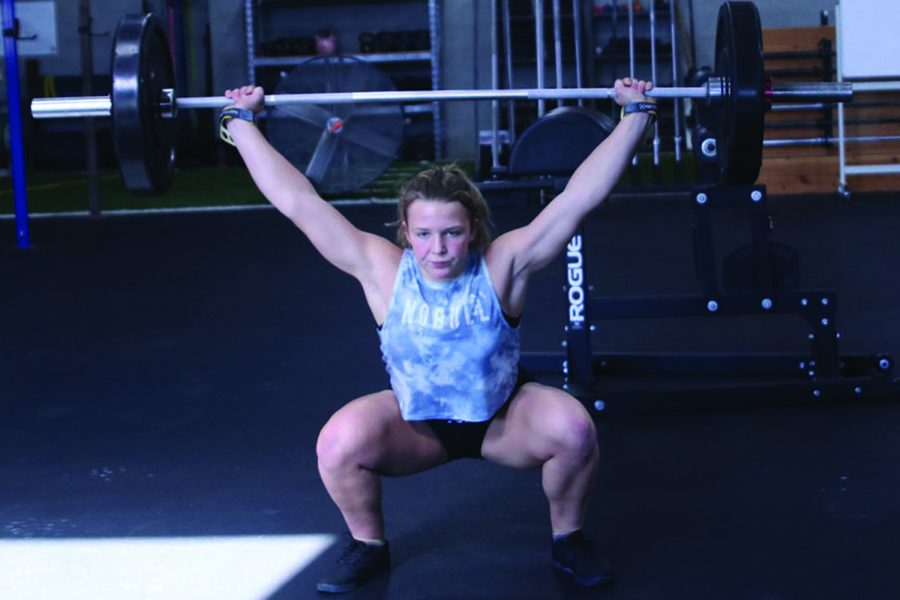 Sophomore+Olivia+Kersetter+finishes+a+snatch+by+lifting+the+weight+above+her+head++