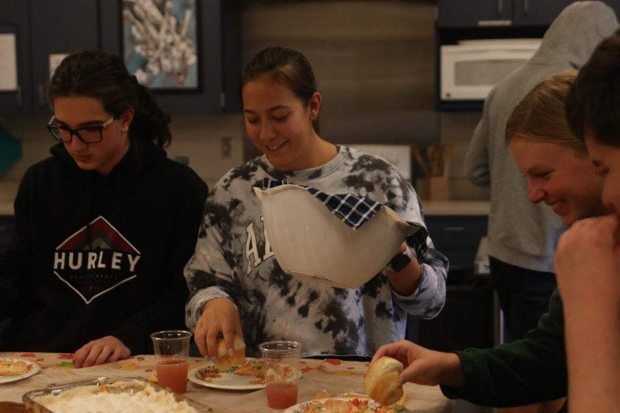 Smiling, senior Kiersten Dupriest places a roll on her plate.