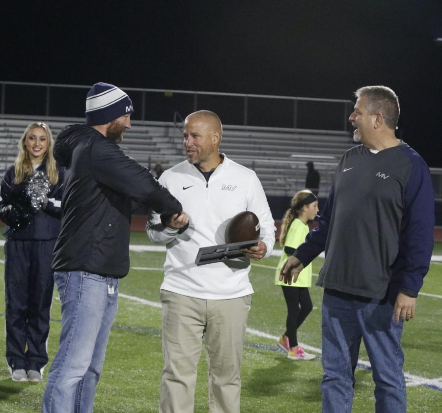 With a smile on his face, head coach Joel Applebee receives a plaque for his 100 career wins.