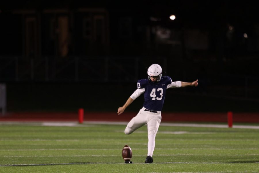 On the football field, Ryan winds his leg back for a kickoff Friday, Oct. 29 for victory over Highland park.